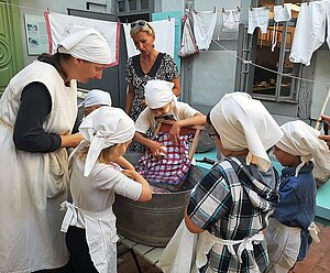Kinder als Waschfrauen verkleidet beim Wäschewaschen (© Meike Jezmann) 